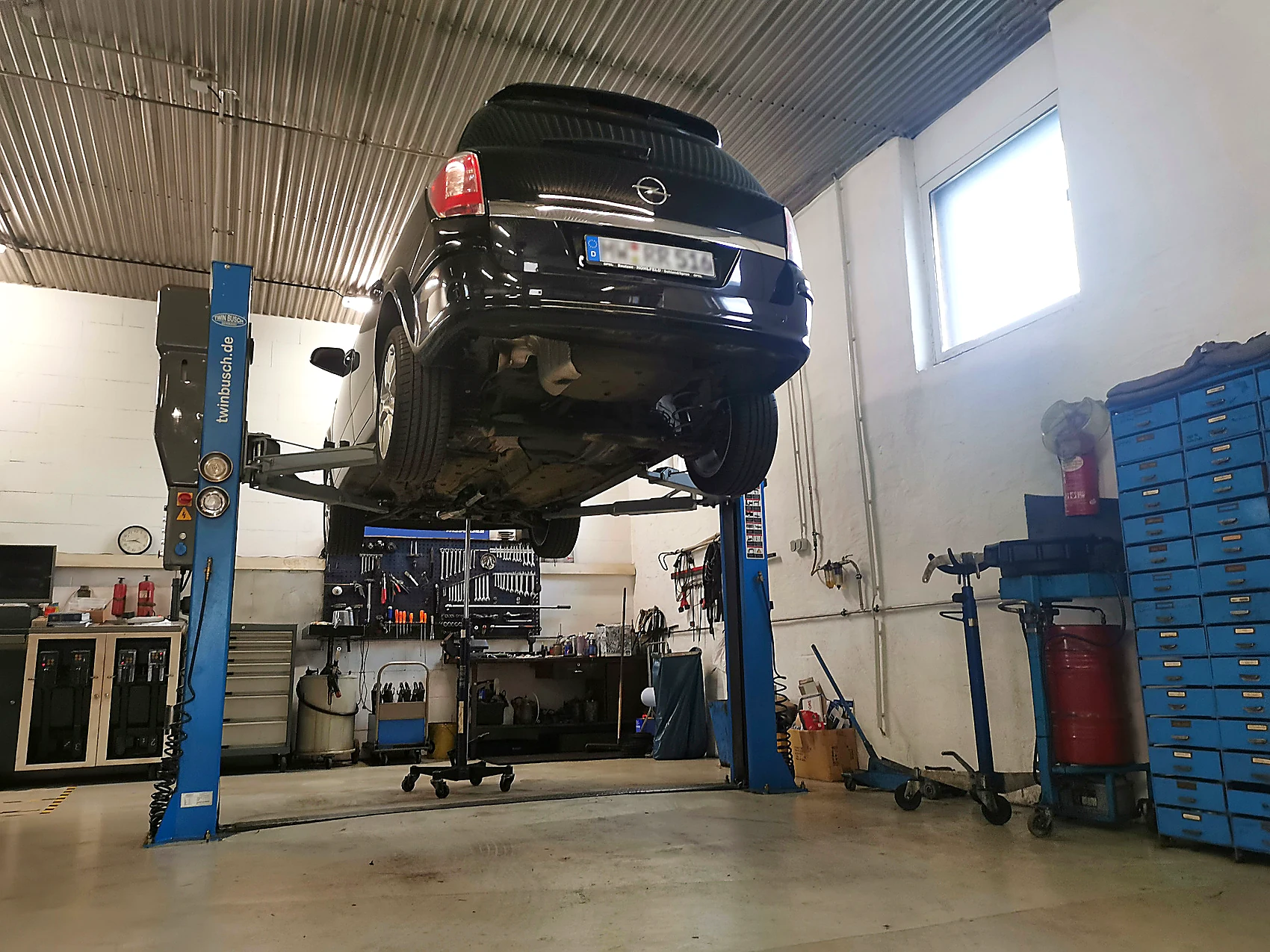 Werkstattinnenraum mit Fahrzeug auf Hebebühne